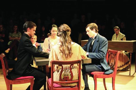 HOUSE OF CARDS St. Marks junior Charles (left), senior Regen, junior Natalie, and St. Marks senior Taylor (right) converse over a game of cards. Junior Jenny plays piano in the background.