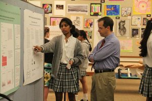 SUMMERTIME SCIENCE Junior Aashima Garg shows her  summer science research to Science Department Chair Dr. Marshall Bartlett at a science research symposium on Sept.19. PHOTO BY SYDNEY YONACK