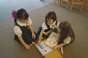 BUILDING TOGETHER Pre-K students Jameson Dondero, Gwendolyn Becker and Maggie Hurley play with a Goldieblox construction set, a toy designed to encourage girls to build their engineering skills. PHOTO BY ALAINA RODRIGUEZ