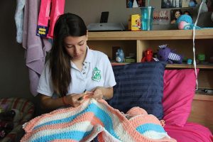 BABY BLANKET Senior Shelby Cohron crochets a blanket for College Counseling Associate Courtney Skerritt, who is expecting a baby girl in August. She began crocheting the blanket before she found out the baby’s gender. “It’s gender neutral,” she said. PHOTO BY TIFFANY LE 