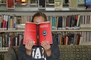 BEHIND THE COVER Freshman Camryn Dixon reads Satrapi's "Persepolis," a novel that is often banned at other schools but is part of the freshmen English curriculum at Hockaday. Credit: Mary Orsak/The Hockaday Fourcast