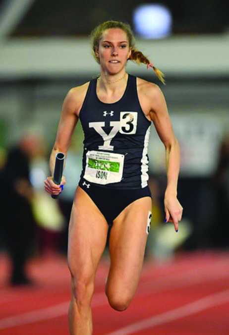 Isom+sprints+down+the+track+with+a+baton+as+she+competes+for+Yale.+