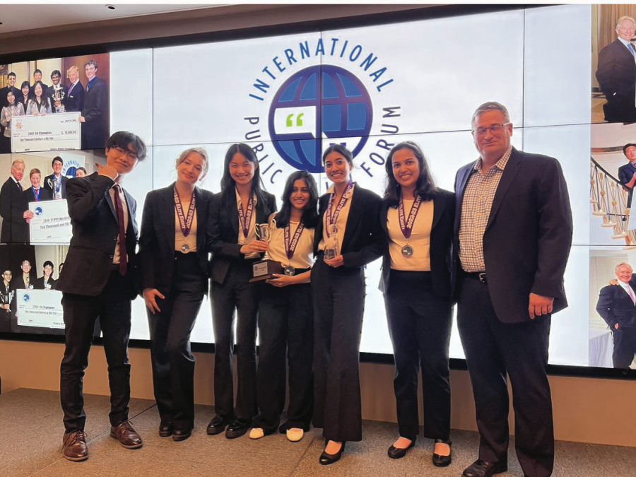 After the final round, the debaters gather for a picture with Thomas Ku, the team’s NYU ambassador and president of the university’s debate team, and Hockaday debate coach Dr. Chuck Walts. The team took second place in the IPPF global tournament.