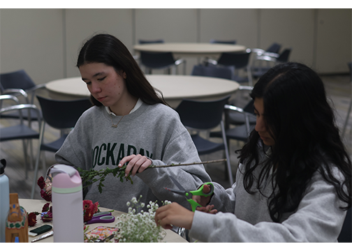 Seniors Alice Navarro'26 and Leela Phillip'26 make flower crowns at the Midsommar session